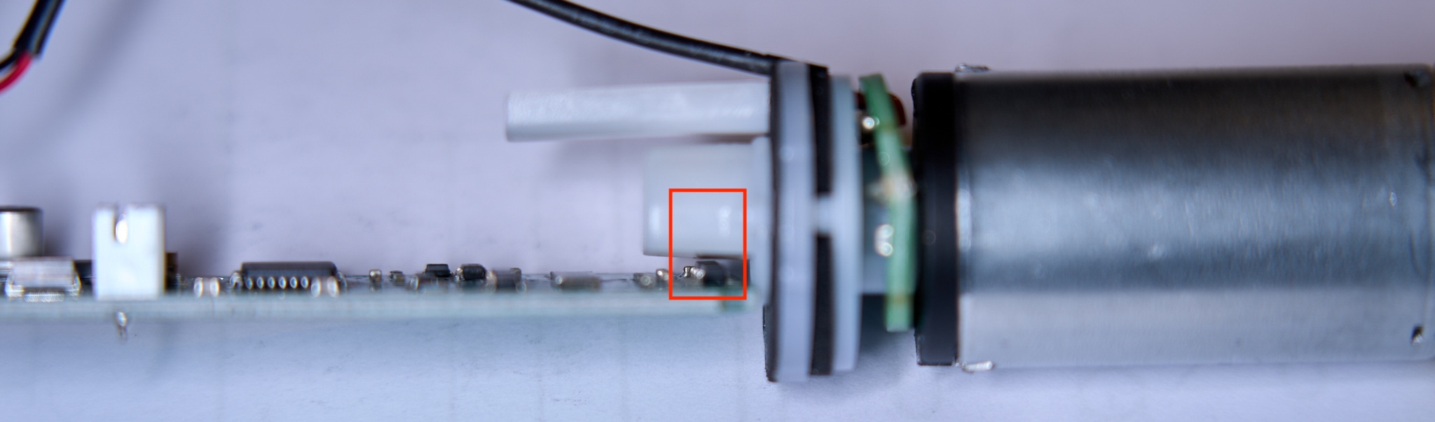 Anordnung des rotierenden Magneten (im Bild überwiegend verdeckt) über den Hall-Sensoren auf der Motorplatine